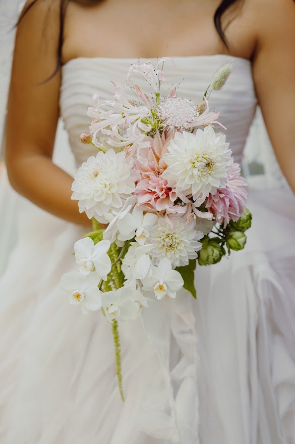 Bride holding a blush and white cascading bouquet